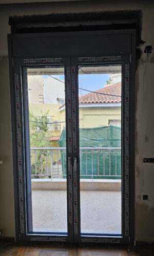 Δίφυλλη μπαλκονόπορτα με σίτα και ηλεκτρικό ρολό επικαθήμενο